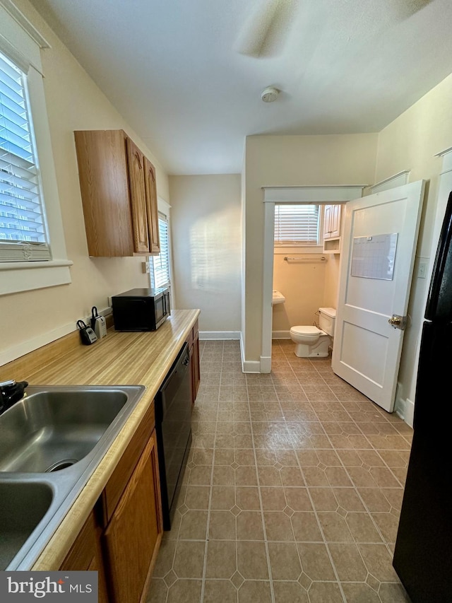 kitchen featuring tile patterned flooring, dishwasher, and sink