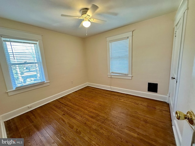 unfurnished room with ceiling fan and dark hardwood / wood-style flooring