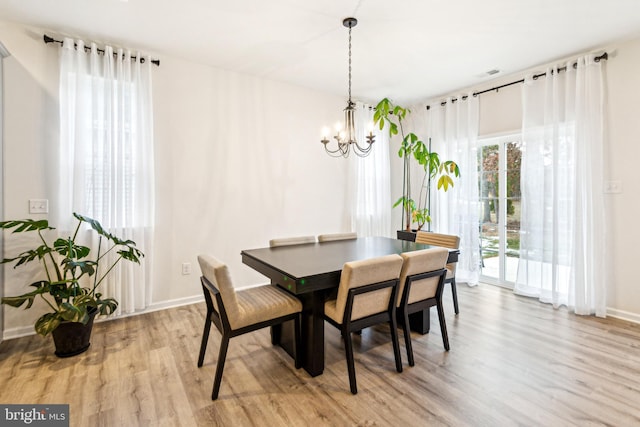 dining room featuring an inviting chandelier and light hardwood / wood-style flooring