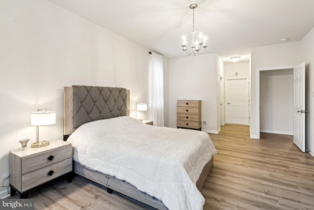 bedroom featuring a notable chandelier and light hardwood / wood-style flooring