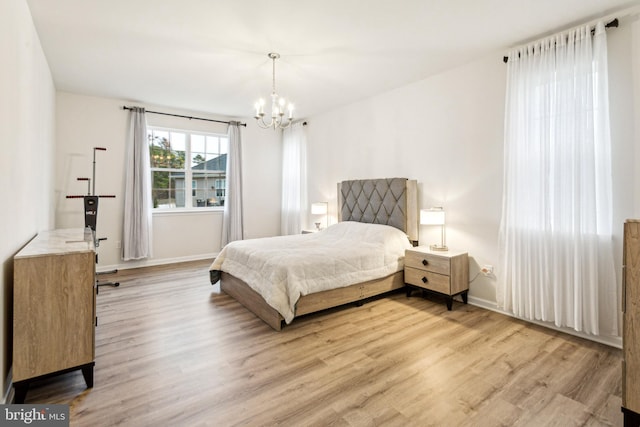 bedroom with a notable chandelier and light wood-type flooring