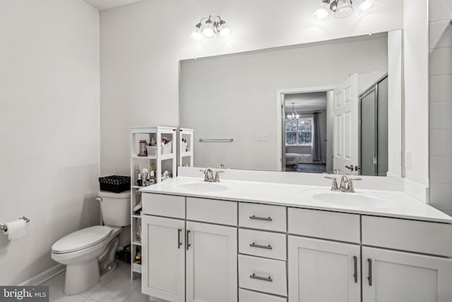 bathroom featuring tile patterned flooring, vanity, toilet, and walk in shower