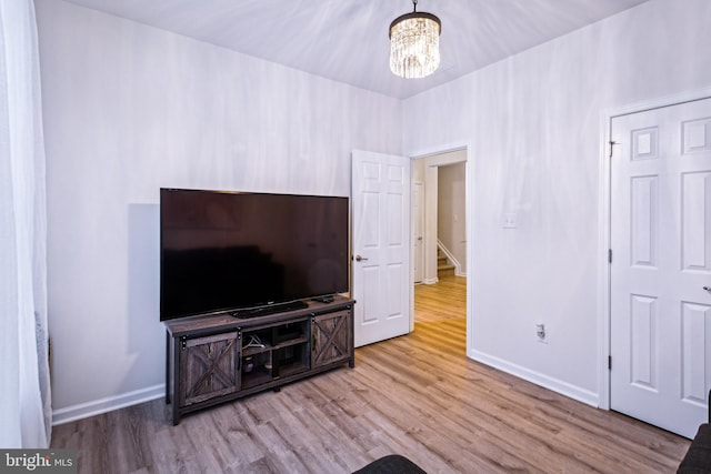 living room with a notable chandelier and light hardwood / wood-style floors