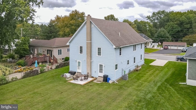 rear view of house with a lawn, a patio area, and central AC unit