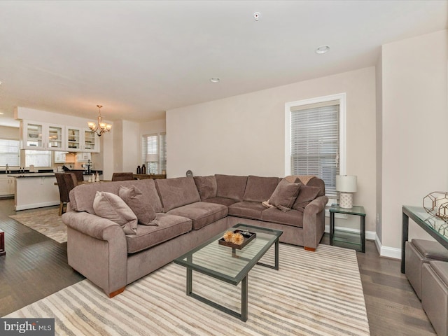 living room with light hardwood / wood-style floors and a notable chandelier