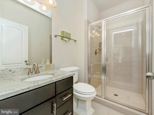 bathroom with tile patterned floors, vanity, toilet, and a shower with shower door