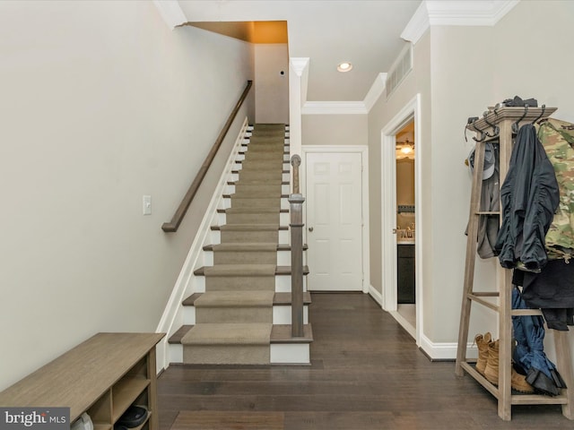 stairs with wood-type flooring and crown molding