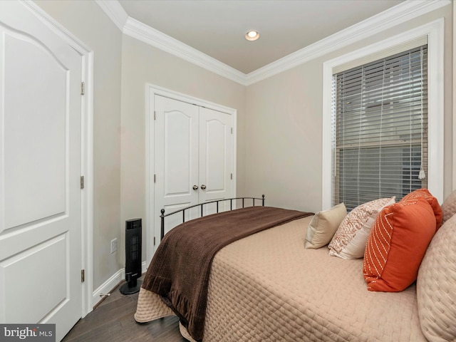 bedroom with a closet, crown molding, and dark hardwood / wood-style flooring