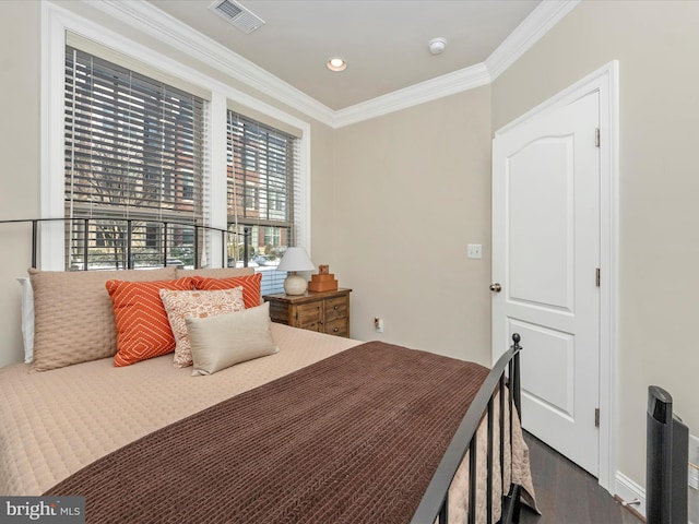 bedroom with dark hardwood / wood-style floors and ornamental molding