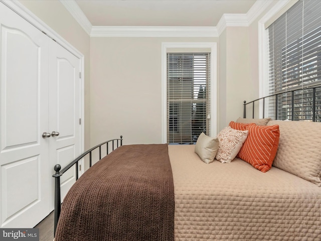 bedroom with hardwood / wood-style flooring, a closet, and crown molding