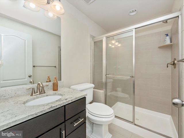 bathroom with tile patterned flooring, vanity, an enclosed shower, and toilet