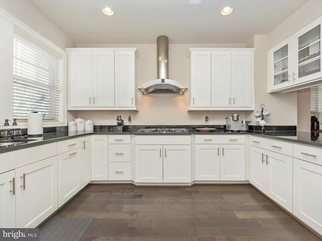 kitchen featuring white cabinetry, sink, wall chimney range hood, dark hardwood / wood-style floors, and stainless steel gas stovetop