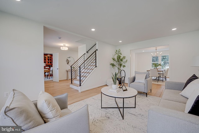 living room with stairs, a notable chandelier, recessed lighting, and light wood finished floors