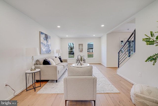 living room featuring recessed lighting, stairway, baseboards, and light wood-style floors