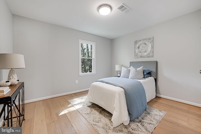 bedroom with light wood-style flooring, baseboards, and visible vents