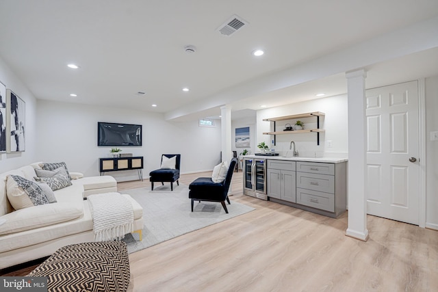 living area with visible vents, recessed lighting, wine cooler, light wood-style floors, and indoor wet bar