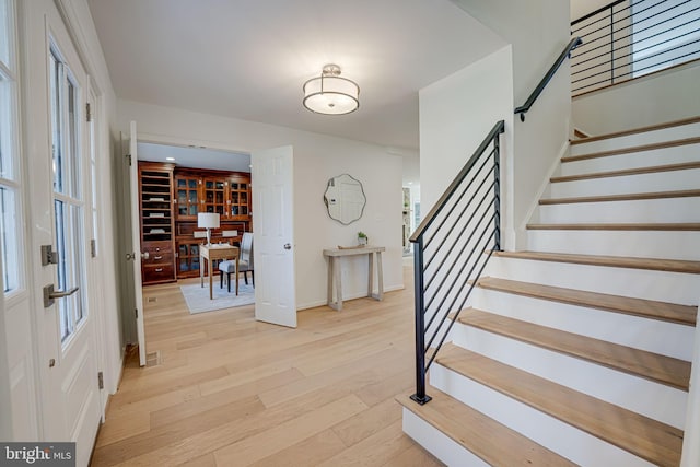 entrance foyer featuring stairway and light wood-style floors