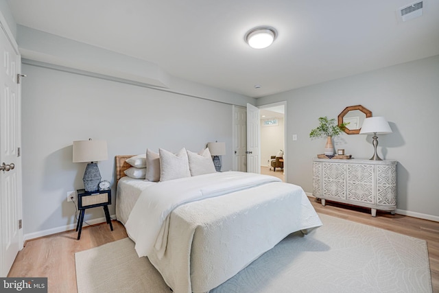 bedroom featuring visible vents, baseboards, and light wood-style floors