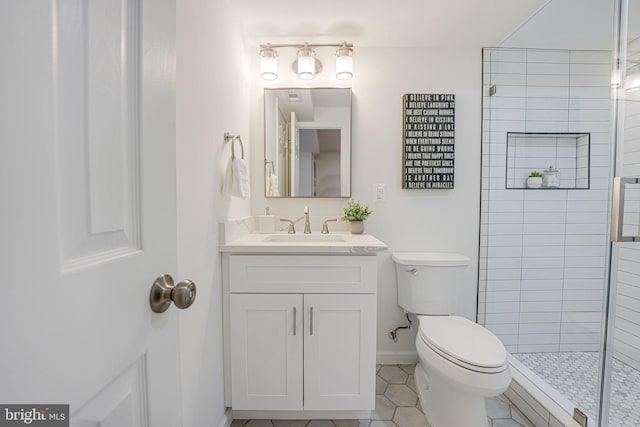 full bath with vanity, baseboards, a tile shower, tile patterned floors, and toilet