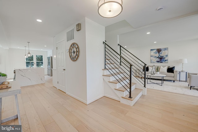 stairway with recessed lighting, visible vents, wood-type flooring, and baseboards