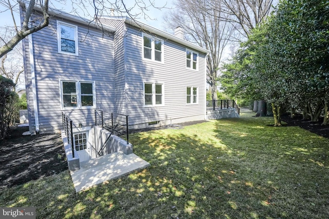 back of property with a lawn and a chimney