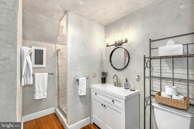 bathroom featuring hardwood / wood-style floors, vanity, toilet, and a shower with door