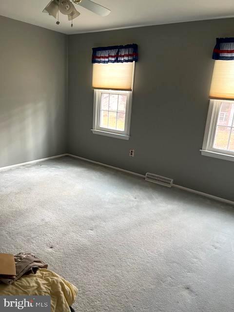 empty room featuring ceiling fan and carpet flooring