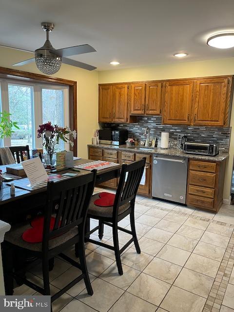 kitchen with tasteful backsplash, sink, dishwasher, and light tile patterned flooring