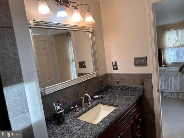 bathroom featuring vanity and tile walls