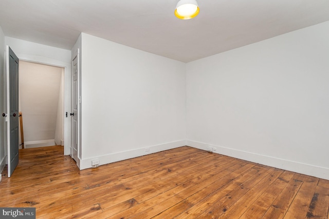 unfurnished room with hardwood / wood-style flooring