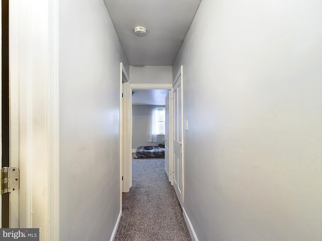 hall featuring dark colored carpet