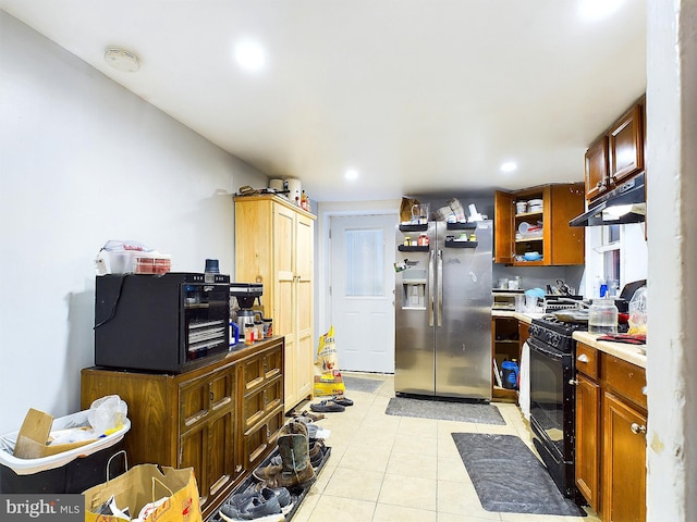 kitchen with stainless steel fridge with ice dispenser, light tile patterned floors, and black range