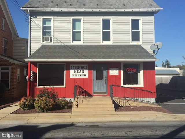 view of front of house featuring cooling unit and roof with shingles