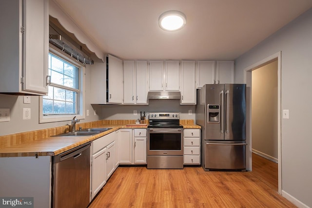 kitchen featuring white cabinets, appliances with stainless steel finishes, sink, and light hardwood / wood-style flooring