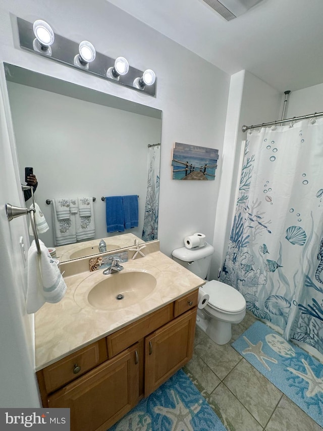 bathroom with tile patterned flooring, vanity, and toilet