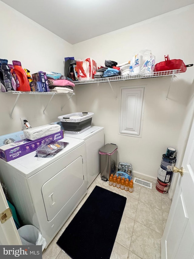 laundry area with light tile patterned flooring and washing machine and clothes dryer