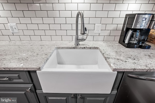 room details featuring tasteful backsplash, dishwashing machine, sink, and light stone countertops