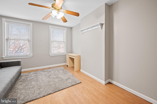 living area with ceiling fan and light hardwood / wood-style flooring