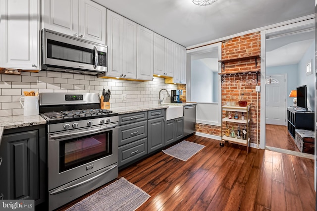 kitchen with light stone countertops, appliances with stainless steel finishes, and white cabinets