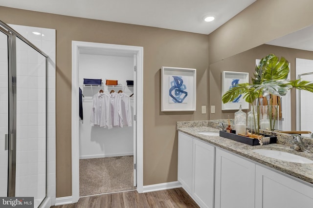 bathroom featuring hardwood / wood-style floors, vanity, and a shower with door