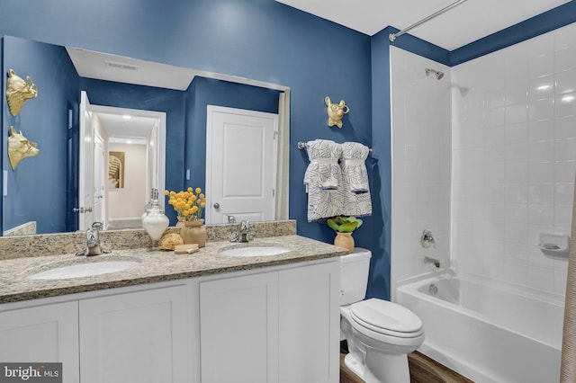 full bathroom featuring hardwood / wood-style flooring, vanity, shower / bathtub combination, and toilet