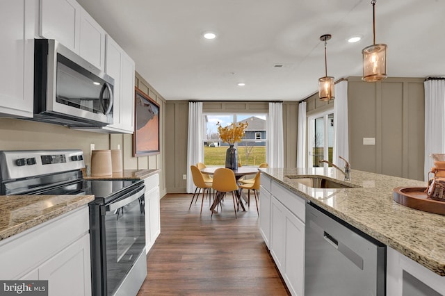 kitchen with sink, light stone countertops, decorative light fixtures, white cabinetry, and stainless steel appliances