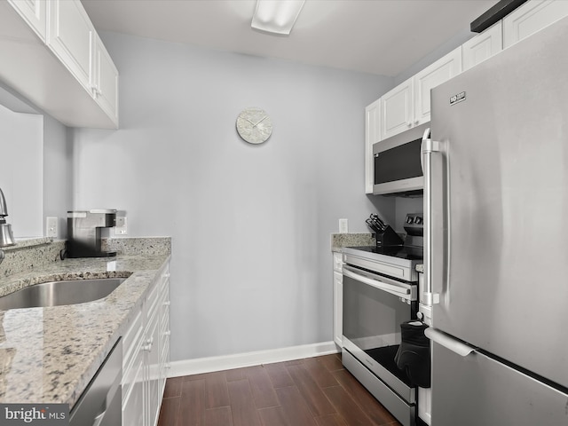 kitchen with sink, light stone countertops, white cabinets, and appliances with stainless steel finishes