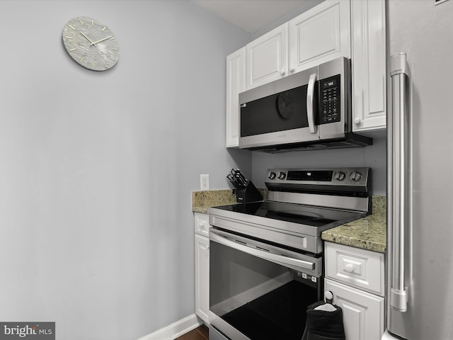 kitchen featuring white cabinetry, stainless steel appliances, and stone countertops