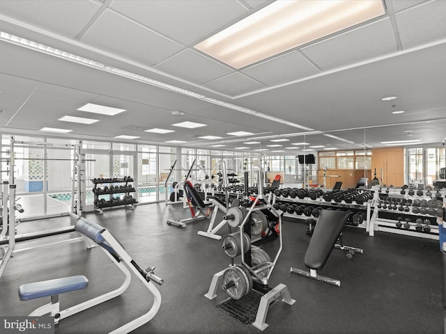 workout area with plenty of natural light and a paneled ceiling