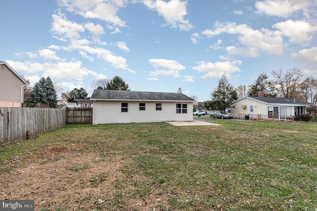 rear view of property with a patio and a lawn