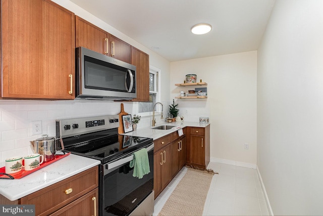 kitchen featuring decorative backsplash, sink, light tile patterned floors, and appliances with stainless steel finishes