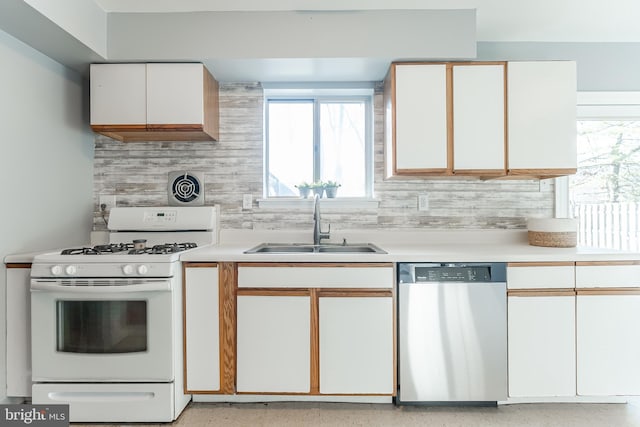 kitchen with decorative backsplash, white gas range, sink, dishwasher, and white cabinetry