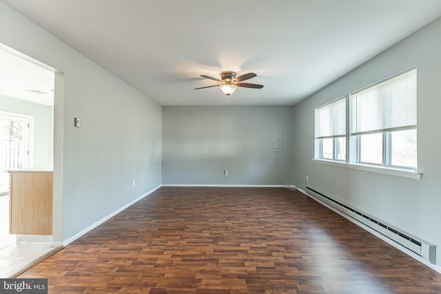 spare room featuring dark hardwood / wood-style floors, baseboard heating, and ceiling fan