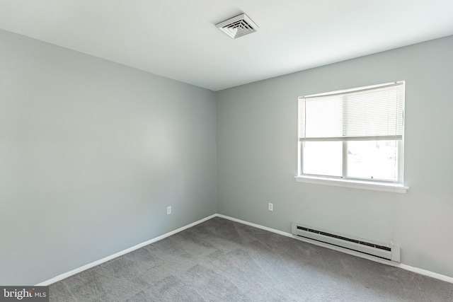 unfurnished room with carpet and a baseboard heating unit